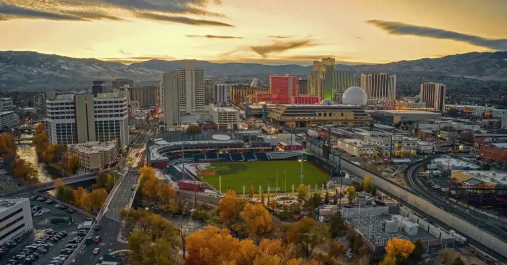 Massage and recovery in Reno NV with the city skyline and baseball stadium at sunset