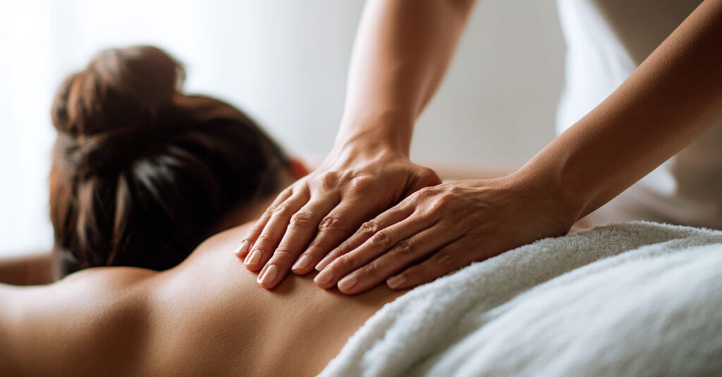 Massage therapist applying firm pressure to a client’s back