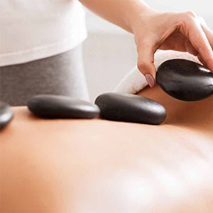 Hot stones placed along the back during a relaxing massage therapy session